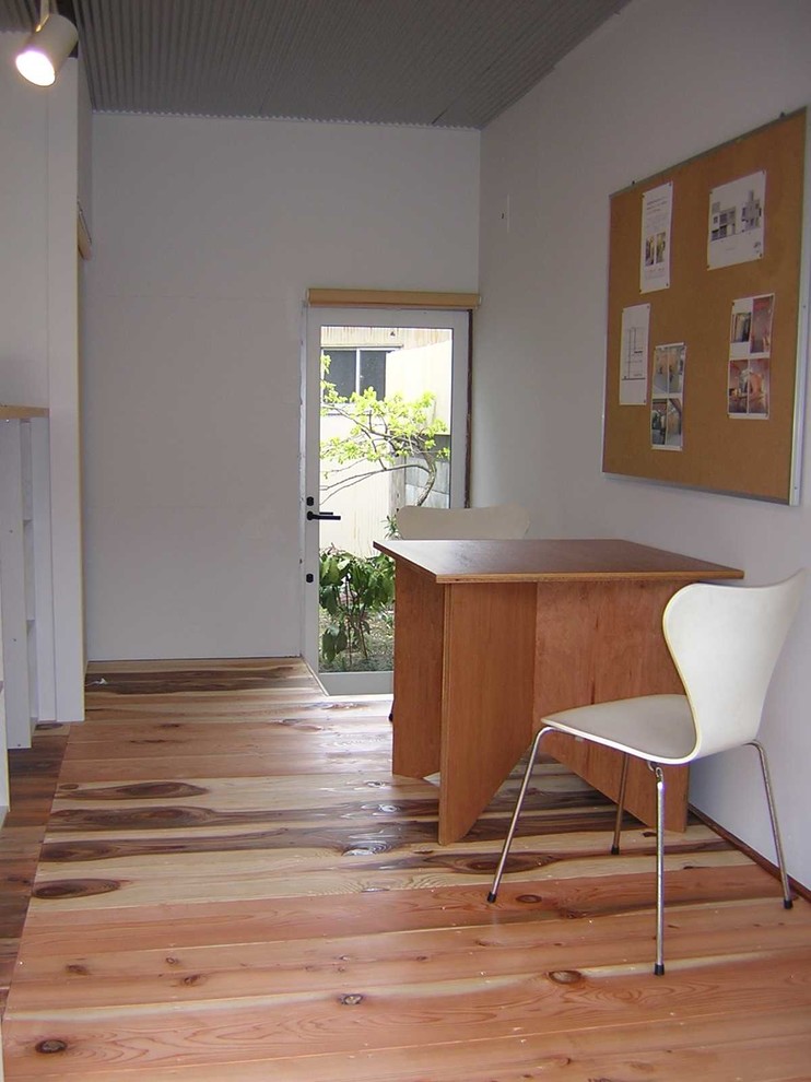 他の地域にある低価格の小さなラスティックスタイルのおしゃれな書斎 (白い壁、淡色無垢フローリング、暖炉なし、自立型机、ベージュの床) の写真