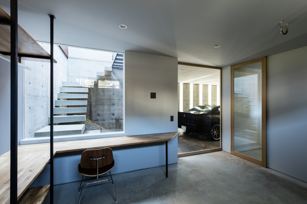 Inspiration för stora moderna hemmastudior, med grå väggar, betonggolv, ett inbyggt skrivbord och grått golv