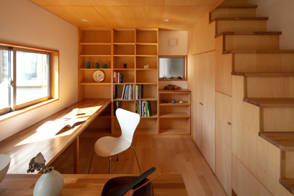 他の地域にあるアジアンスタイルのおしゃれなホームオフィス・書斎 (茶色い壁、無垢フローリング、造り付け机、茶色い床、パネル壁) の写真