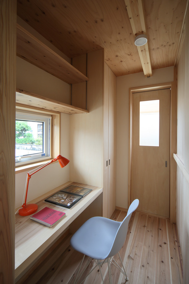 Foto di uno studio etnico con pareti beige, parquet chiaro, scrivania incassata e pavimento beige