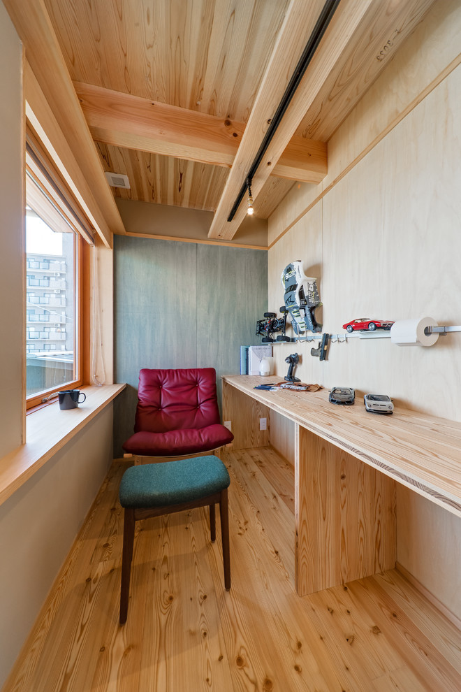 Imagen de despacho asiático pequeño con paredes marrones, suelo de madera en tonos medios, escritorio empotrado y suelo marrón