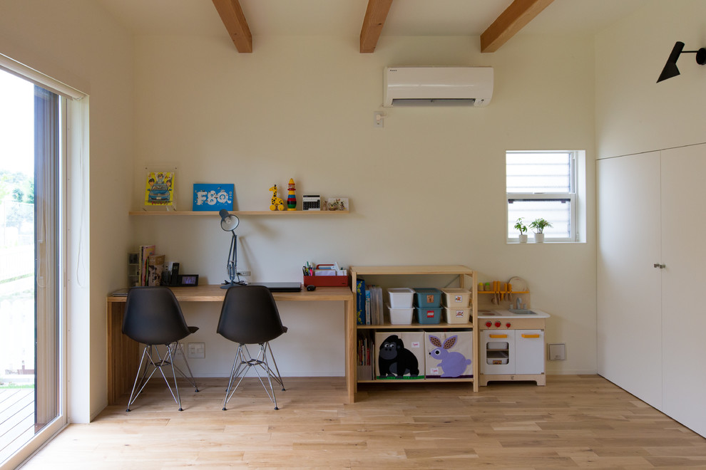 Modernes Arbeitszimmer mit weißer Wandfarbe, hellem Holzboden, freistehendem Schreibtisch und beigem Boden in Nagoya