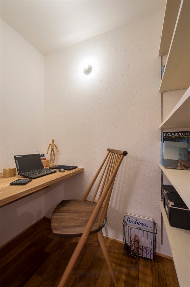 他の地域にある小さなアジアンスタイルのおしゃれなホームオフィス・書斎 (白い壁、無垢フローリング、造り付け机、茶色い床) の写真