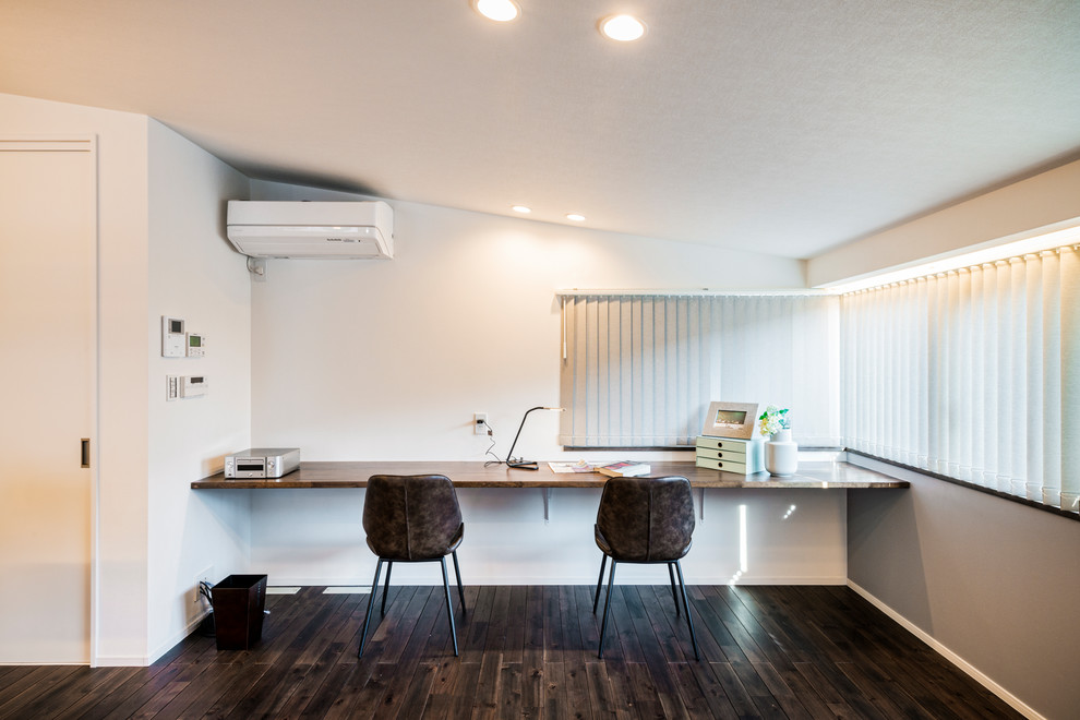 Idéer för funkis arbetsrum, med vita väggar, målat trägolv, ett inbyggt skrivbord och brunt golv
