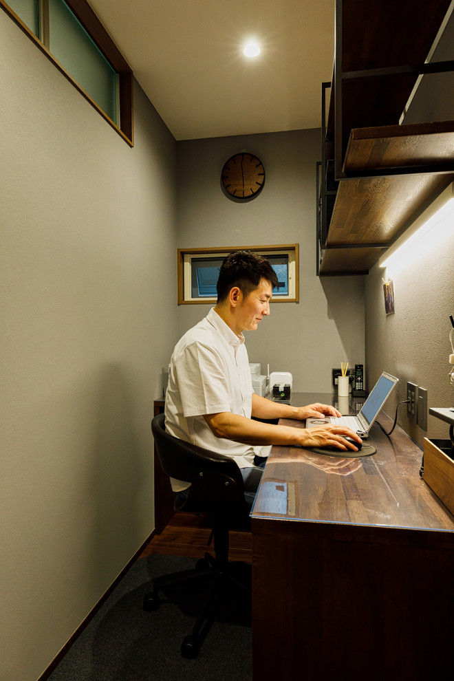Mittelgroßes Modernes Arbeitszimmer mit Arbeitsplatz, grauer Wandfarbe, dunklem Holzboden, Einbau-Schreibtisch, braunem Boden, Tapetendecke und Tapetenwänden in Tokio Peripherie
