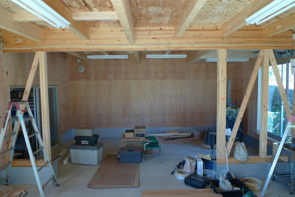 Esempio di un atelier moderno di medie dimensioni con pavimento in cemento, stufa a legna, cornice del camino in cemento, pavimento grigio, soffitto in legno e pareti in legno