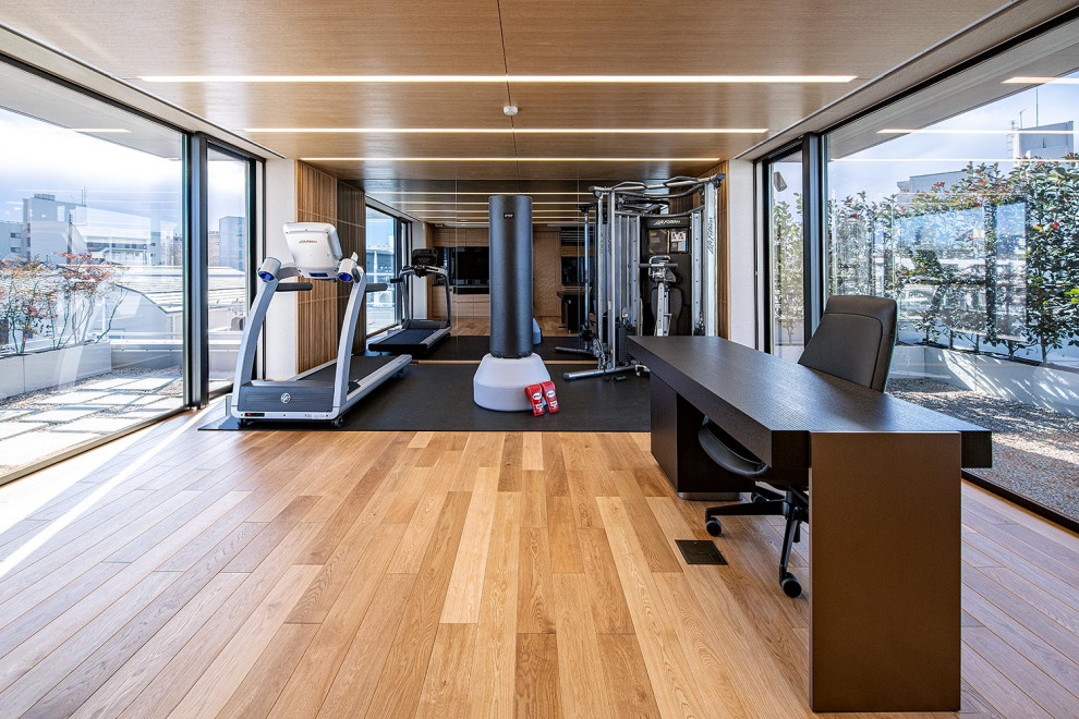 Modernes Arbeitszimmer ohne Kamin mit Arbeitsplatz, brauner Wandfarbe, braunem Holzboden, freistehendem Schreibtisch und braunem Boden