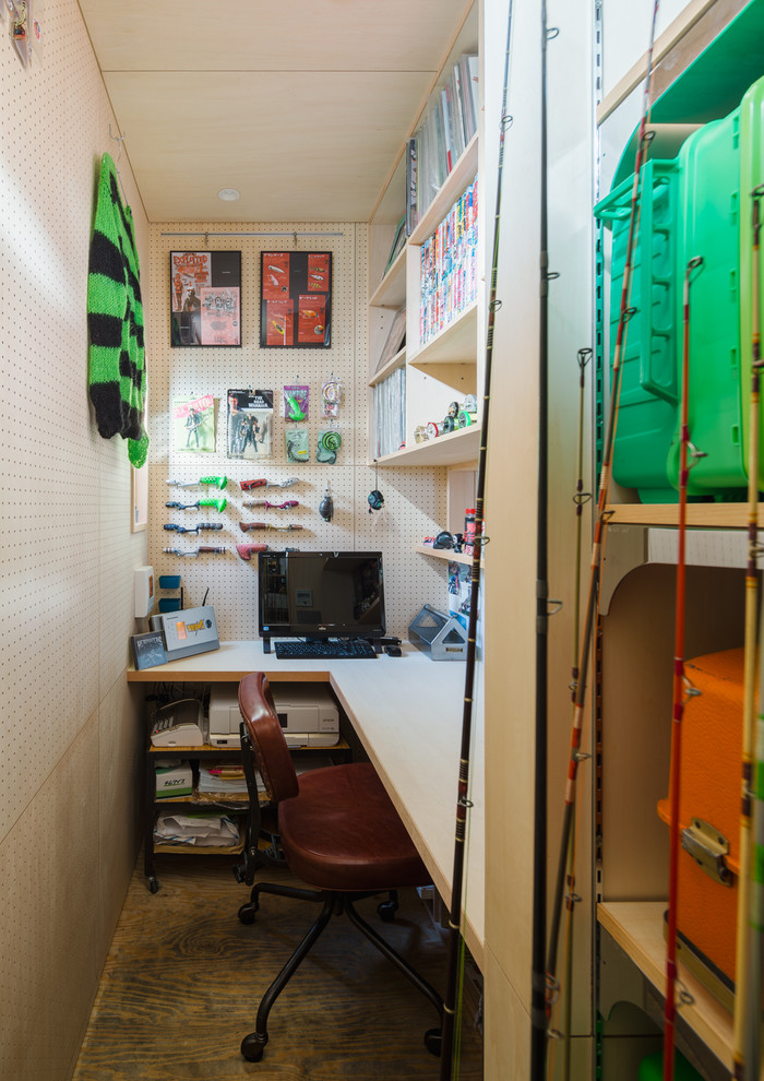 他の地域にある小さな北欧スタイルのおしゃれなホームオフィス・書斎 (ベージュの壁、造り付け机、茶色い床) の写真