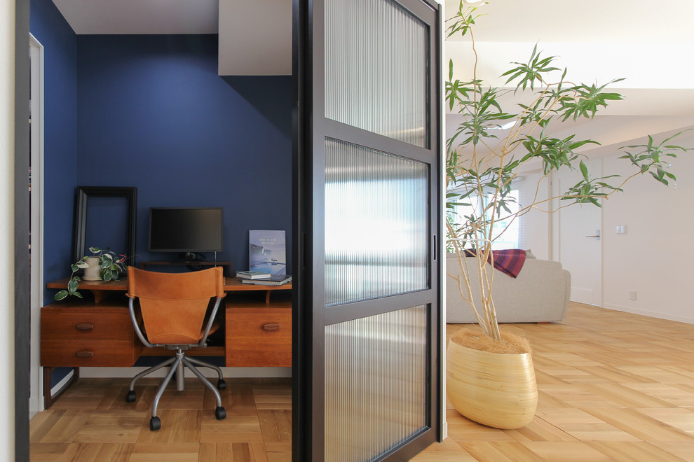 Inspiration för små moderna arbetsrum, med blå väggar, mellanmörkt trägolv, ett inbyggt skrivbord och beiget golv
