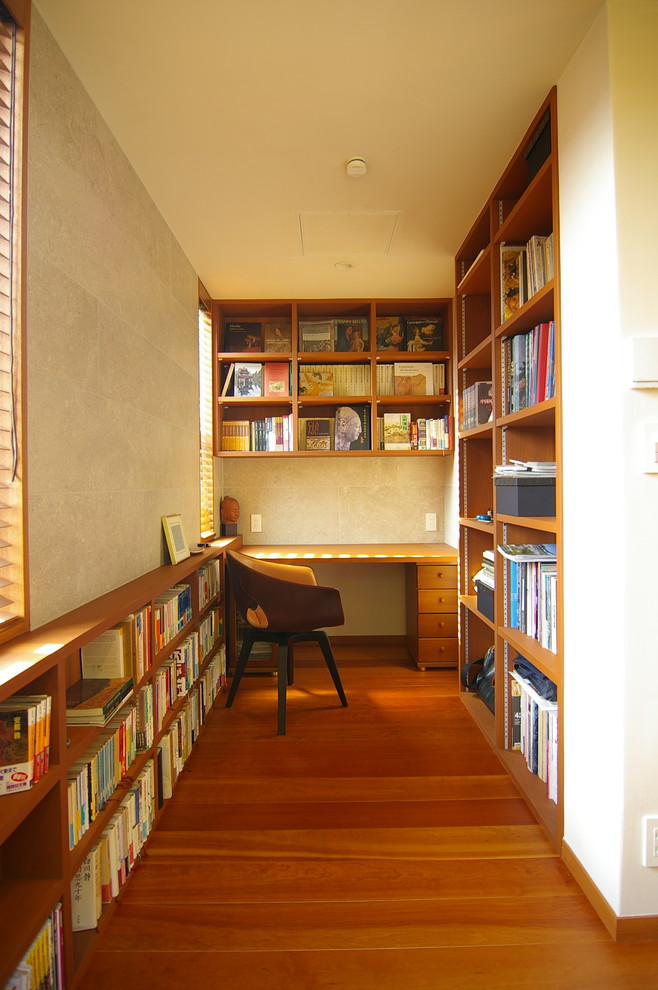 Inspiration pour un bureau vintage avec un mur beige, un sol en bois brun, aucune cheminée, un bureau intégré et un sol marron.