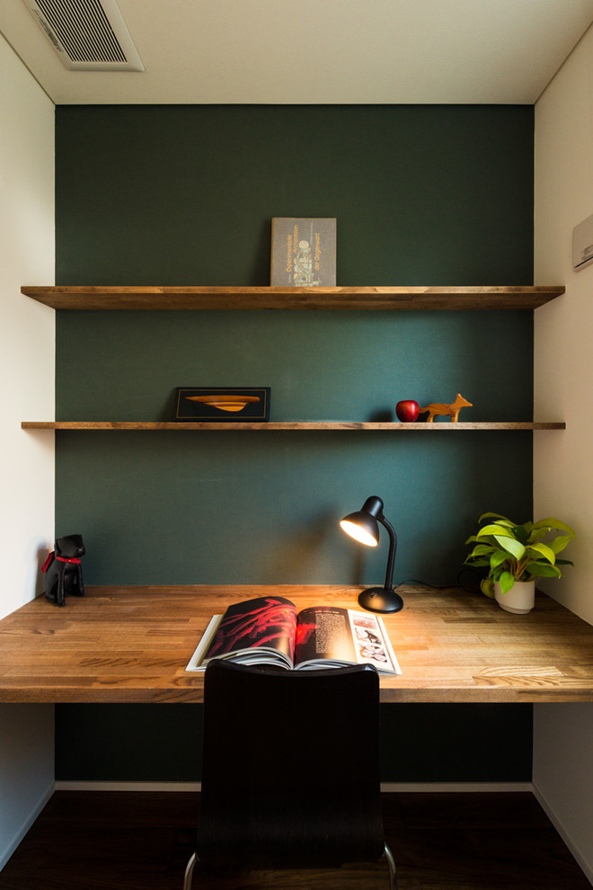 Kleines Skandinavisches Arbeitszimmer ohne Kamin mit Einbau-Schreibtisch, Arbeitsplatz und grüner Wandfarbe in Sonstige