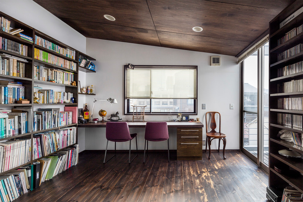 Imagen de despacho clásico con paredes blancas, suelo de madera oscura y escritorio empotrado