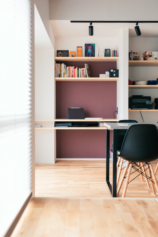 Foto de despacho urbano de tamaño medio con paredes rojas, suelo de madera clara, escritorio empotrado, suelo beige, papel pintado y papel pintado