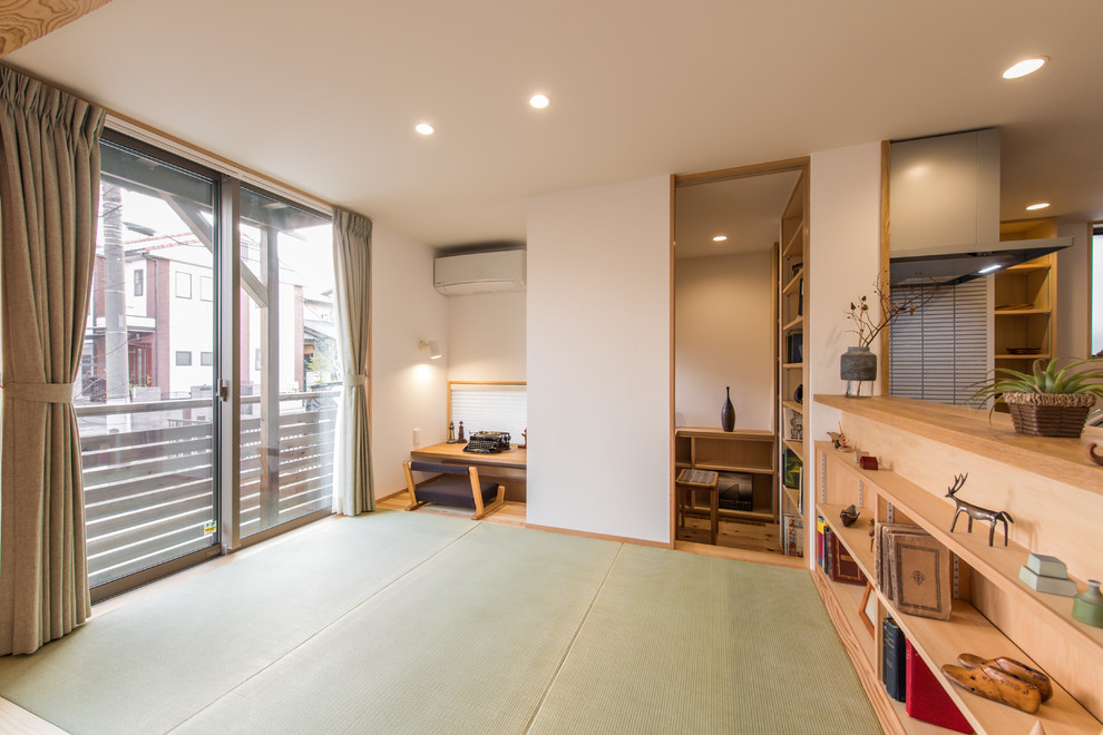 Inredning av ett asiatiskt arbetsrum, med vita väggar, tatamigolv, ett inbyggt skrivbord och grönt golv