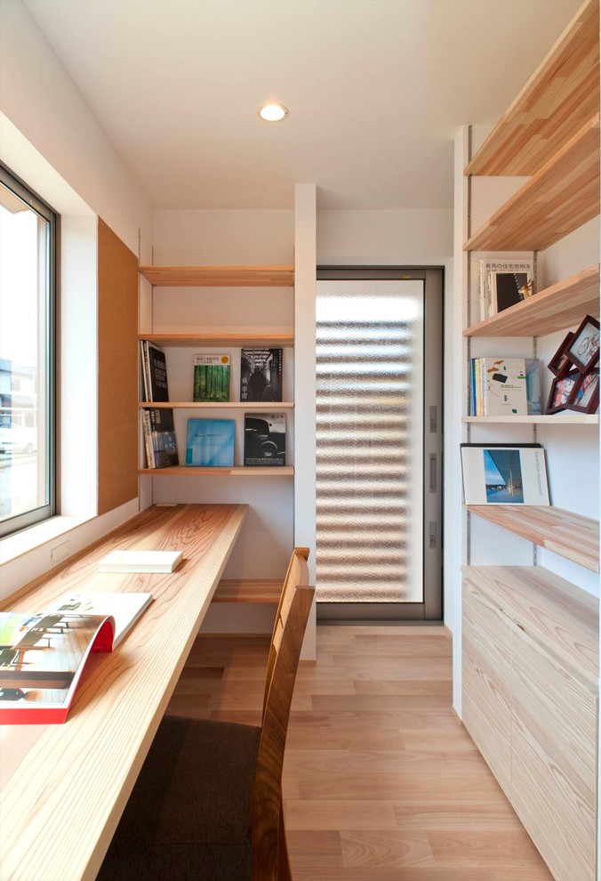 他の地域にあるコンテンポラリースタイルのおしゃれなホームオフィス・書斎 (白い壁、淡色無垢フローリング、造り付け机、ベージュの床) の写真