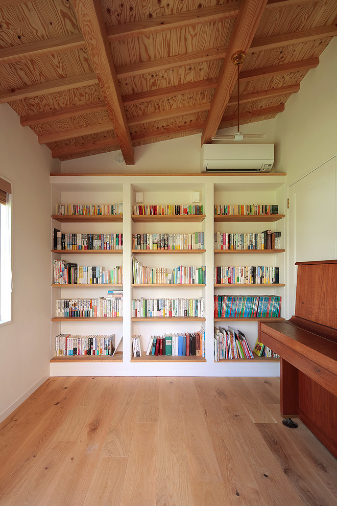 Idée de décoration pour un bureau nordique avec une bibliothèque ou un coin lecture et un sol en bois brun.