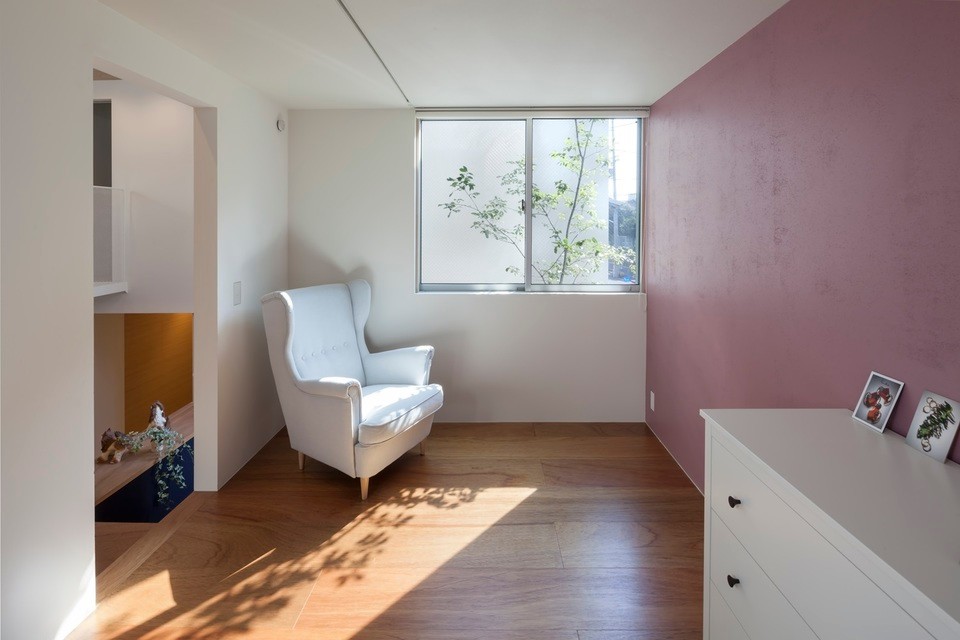 Inspiration för ett mellanstort funkis hemmabibliotek, med rosa väggar, mellanmörkt trägolv och beiget golv