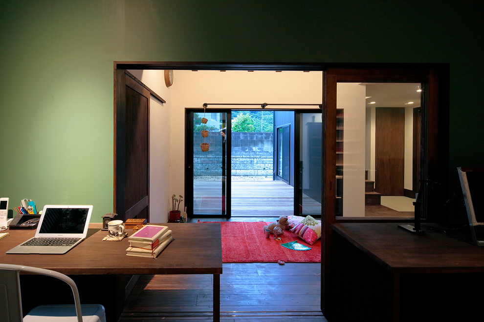 Idéer för ett mellanstort 50 tals hemmabibliotek, med gröna väggar, mörkt trägolv, ett inbyggt skrivbord och brunt golv