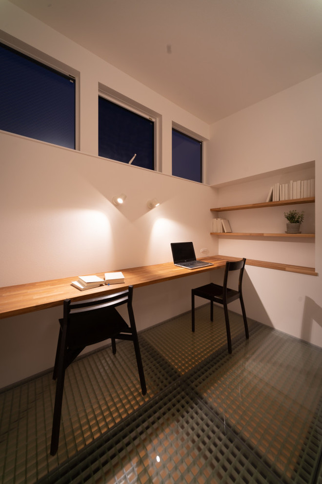 Modelo de despacho de estilo zen pequeño sin chimenea con paredes blancas y escritorio empotrado