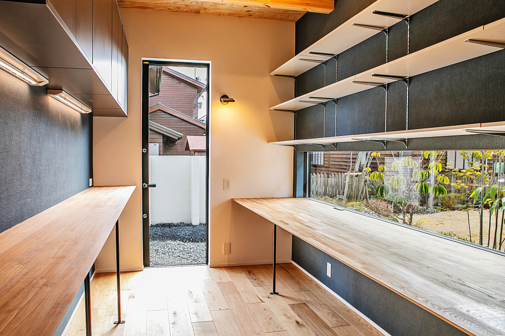 This is an example of a contemporary home studio in Kyoto with blue walls, light hardwood flooring, no fireplace, a built-in desk and a wood ceiling.