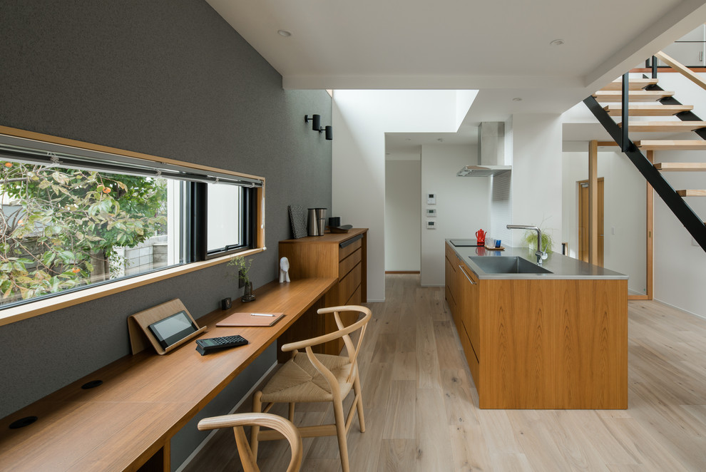 Modelo de despacho escandinavo con paredes grises, suelo de madera pintada, escritorio empotrado y suelo gris