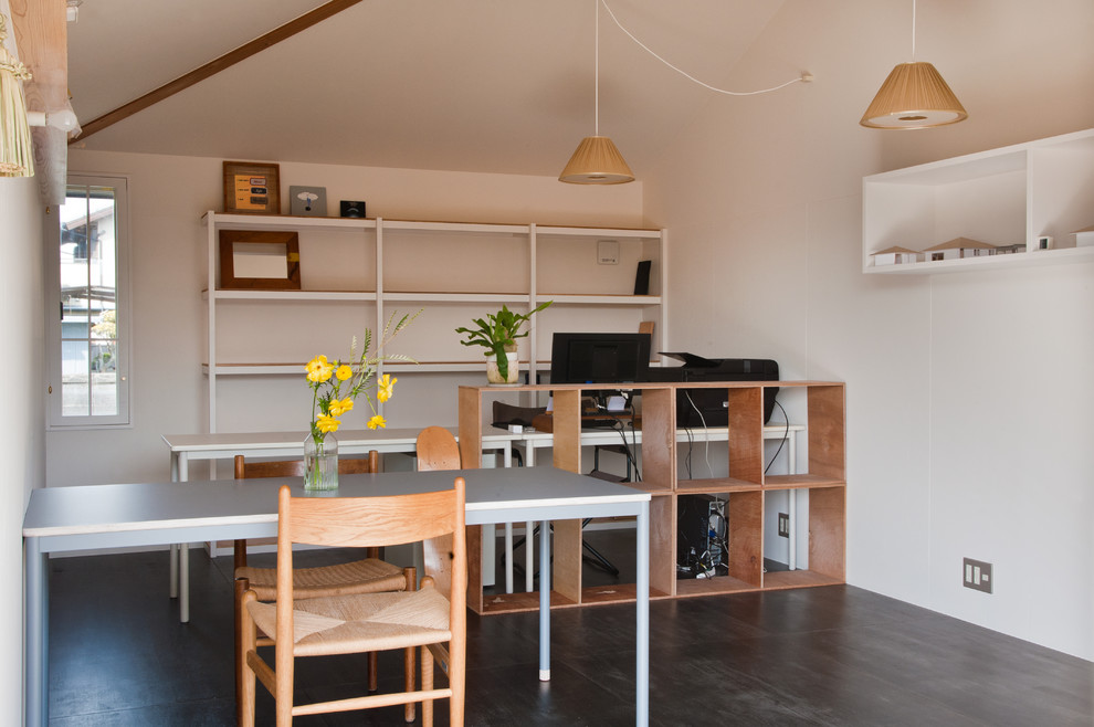 На фото: кабинет в скандинавском стиле с белыми стенами, деревянным полом, отдельно стоящим рабочим столом и черным полом с