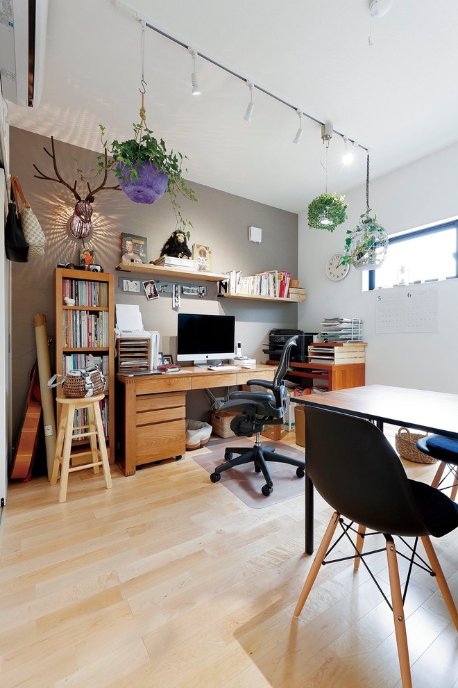 На фото: кабинет в стиле лофт с серыми стенами, светлым паркетным полом, отдельно стоящим рабочим столом и коричневым полом