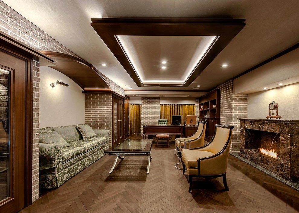 トラディショナルスタイルのおしゃれな書斎 (ベージュの壁、濃色無垢フローリング、横長型暖炉、自立型机、茶色い床) の写真