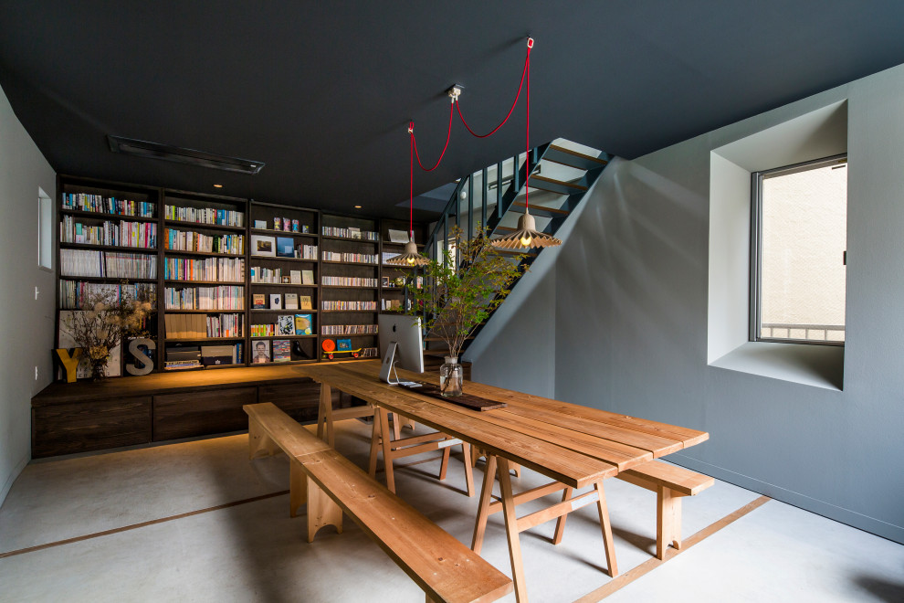 Cette photo montre un bureau tendance avec une bibliothèque ou un coin lecture, un mur gris, un bureau indépendant et un sol gris.