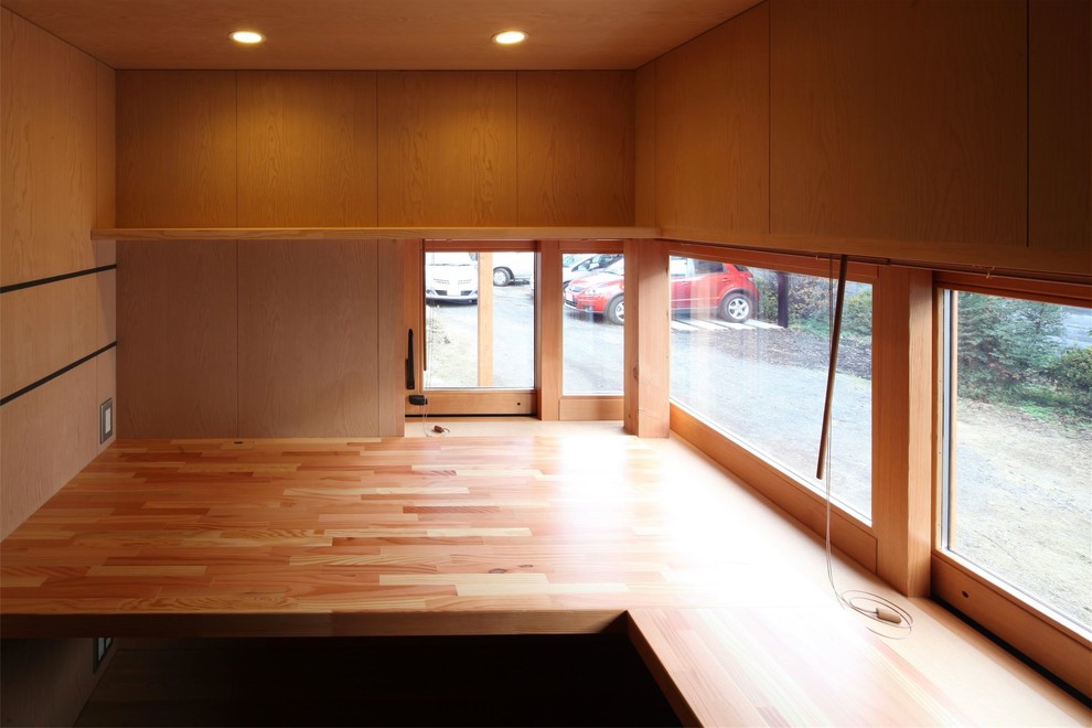 Réalisation d'un bureau nordique avec un mur marron, un sol en bois brun, aucune cheminée et un bureau intégré.