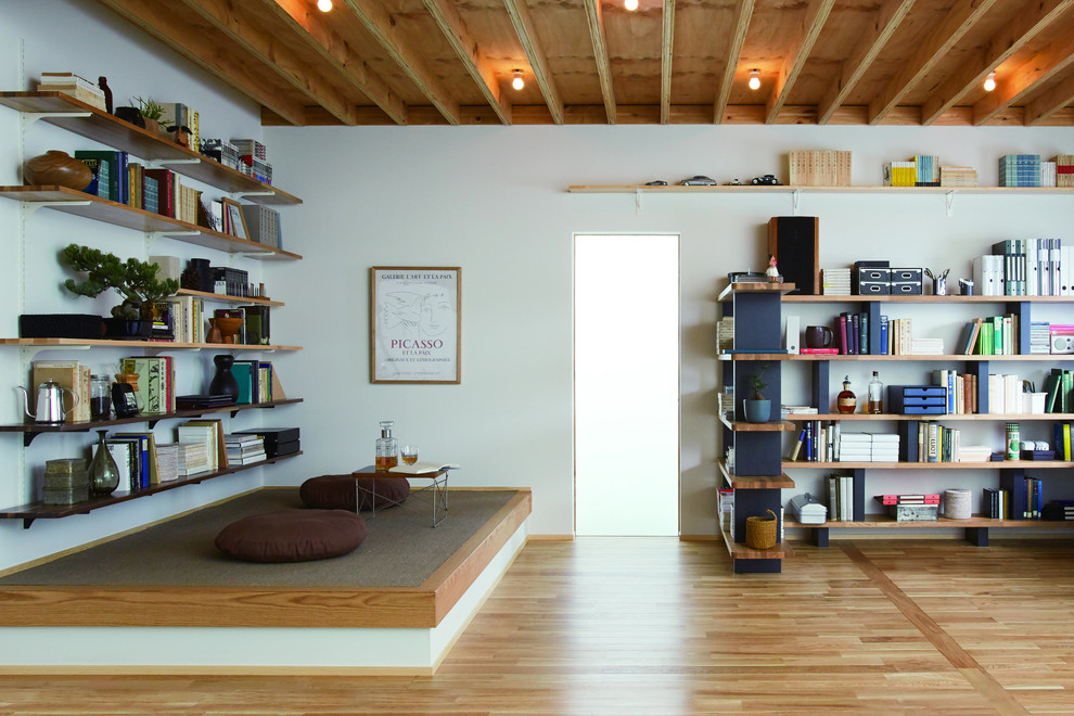 This is an example of a world-inspired home office in Other with white walls, medium hardwood flooring and brown floors.