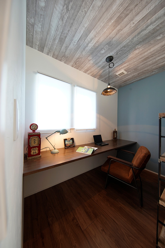 他の地域にあるビーチスタイルのおしゃれなホームオフィス・書斎 (マルチカラーの壁、濃色無垢フローリング、茶色い床、造り付け机) の写真