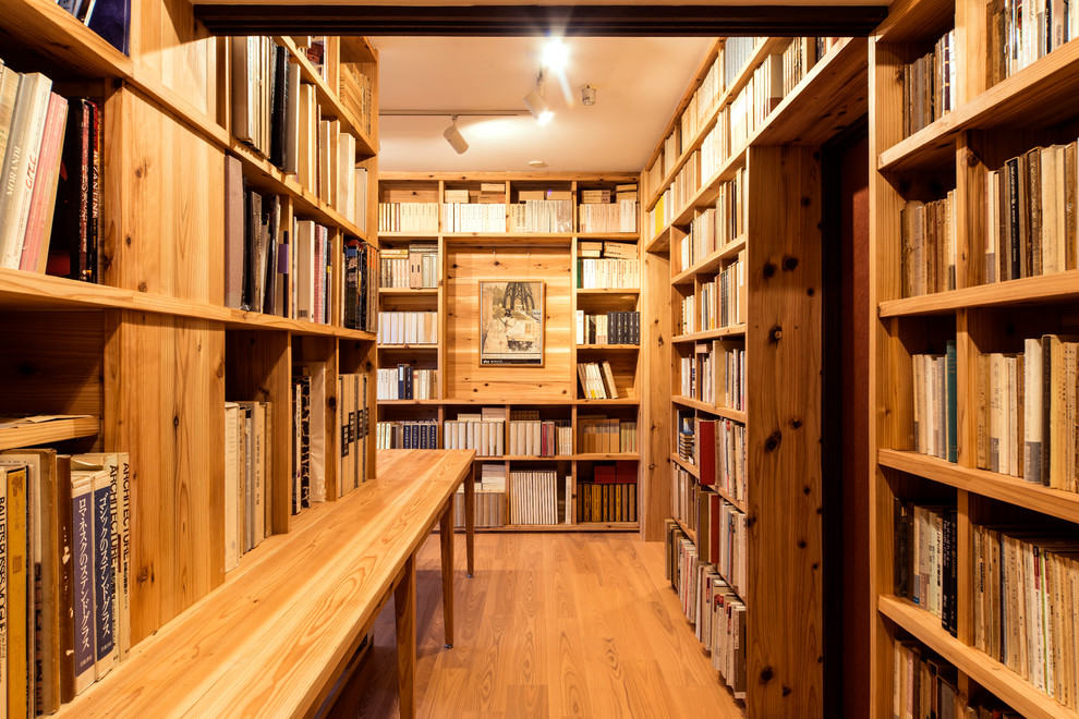 Idéer för att renovera ett mellanstort nordiskt arbetsrum, med ett bibliotek, beige väggar, ljust trägolv, ett inbyggt skrivbord och beiget golv