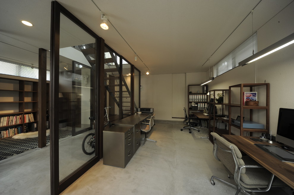 東京23区にある小さなインダストリアルスタイルのおしゃれなホームオフィス・書斎 (白い壁、コンクリートの床、自立型机、グレーの床) の写真