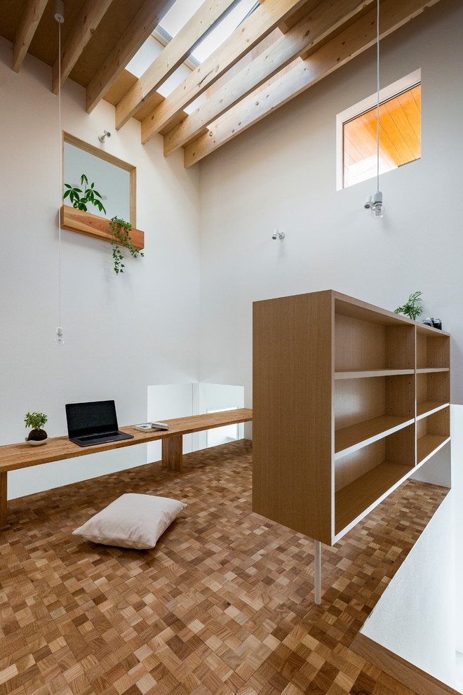 他の地域にあるアジアンスタイルのおしゃれなホームオフィス・書斎 (白い壁、無垢フローリング、造り付け机、茶色い床) の写真