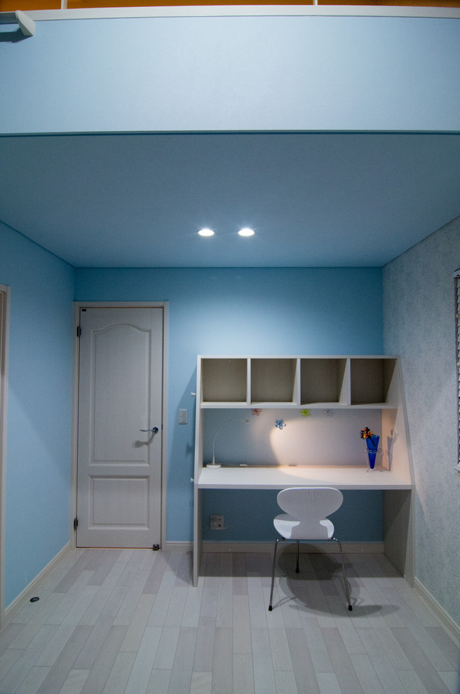 Стильный дизайн: кабинет в стиле модернизм с синими стенами, деревянным полом, отдельно стоящим рабочим столом и серым полом - последний тренд