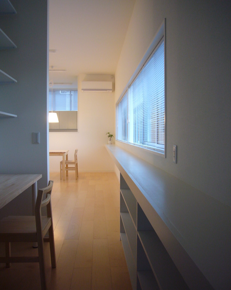 Immagine di un ufficio minimalista di medie dimensioni con pareti bianche, pavimento in compensato, scrivania autoportante e pavimento beige