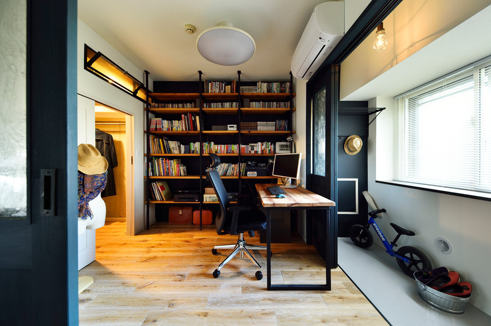 東京23区にあるインダストリアルスタイルのおしゃれなホームオフィス・書斎 (白い壁、無垢フローリング、自立型机、茶色い床) の写真