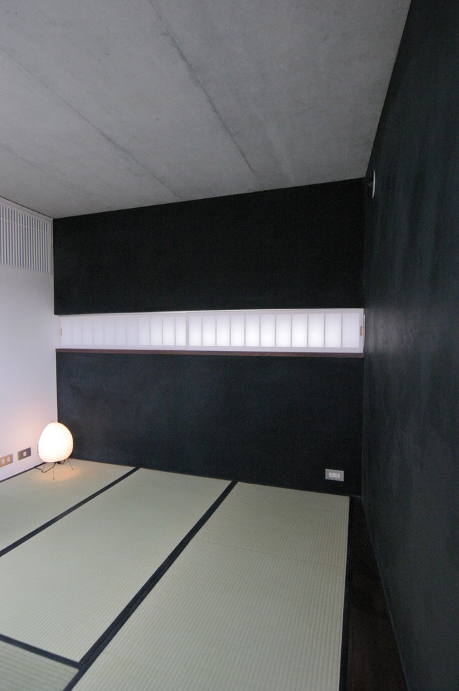 Foto de estudio asiático de tamaño medio con paredes negras, tatami, estufa de leña y marco de chimenea de metal