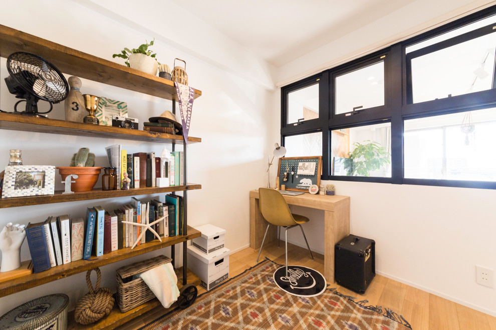 Idee per un piccolo studio minimalista con pareti bianche, parquet chiaro, scrivania incassata e pavimento marrone