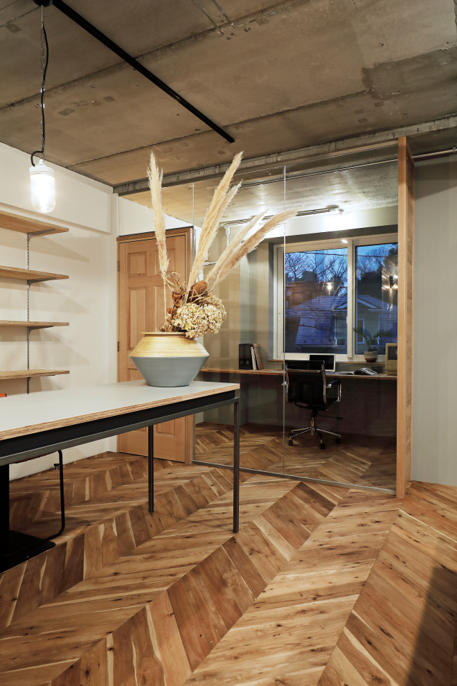Contemporary study in Tokyo with white walls, medium hardwood flooring and no fireplace.