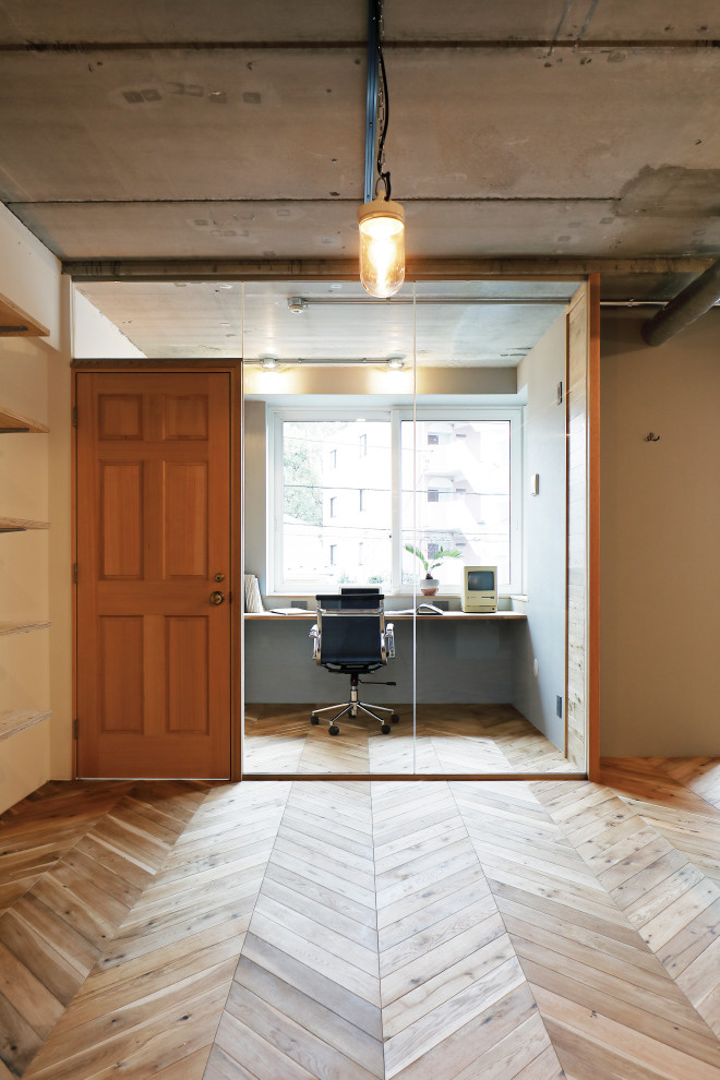 This is an example of a contemporary study in Tokyo with white walls, medium hardwood flooring and no fireplace.