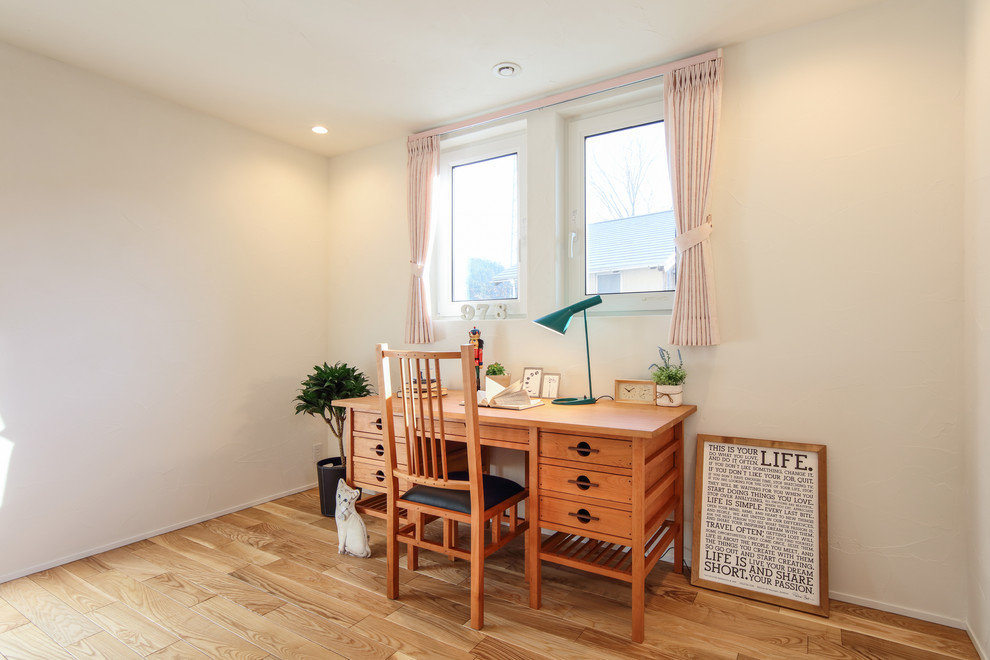 Cette image montre un bureau minimaliste de taille moyenne avec un mur blanc, parquet clair, un bureau indépendant et un sol beige.