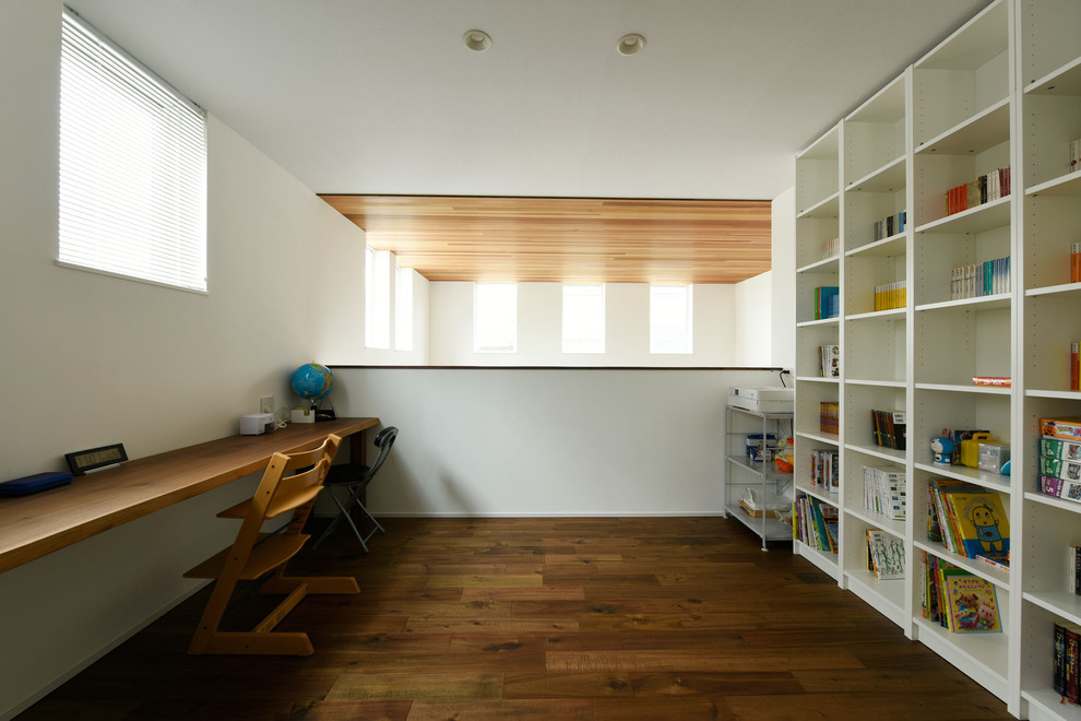Modernes Lesezimmer ohne Kamin mit weißer Wandfarbe, dunklem Holzboden und Einbau-Schreibtisch in Osaka