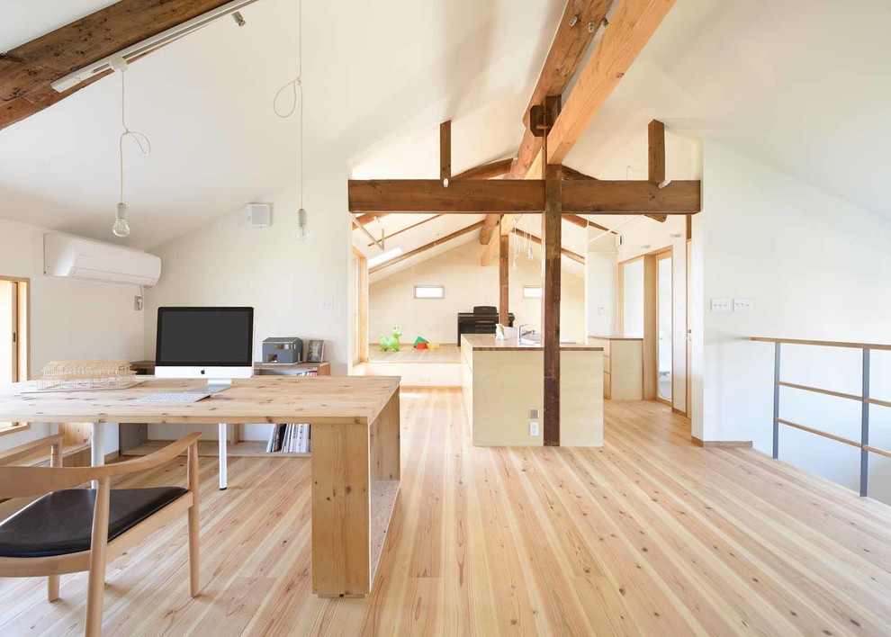 Asiatisches Arbeitszimmer mit weißer Wandfarbe, hellem Holzboden, braunem Boden, freistehendem Schreibtisch und freigelegten Dachbalken in Sonstige