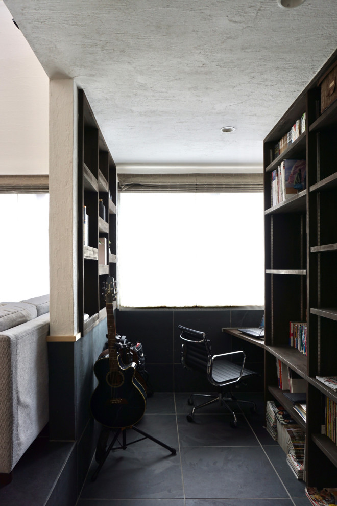他の地域にある小さなモダンスタイルのおしゃれな書斎 (黒い壁、造り付け机、黒い床) の写真