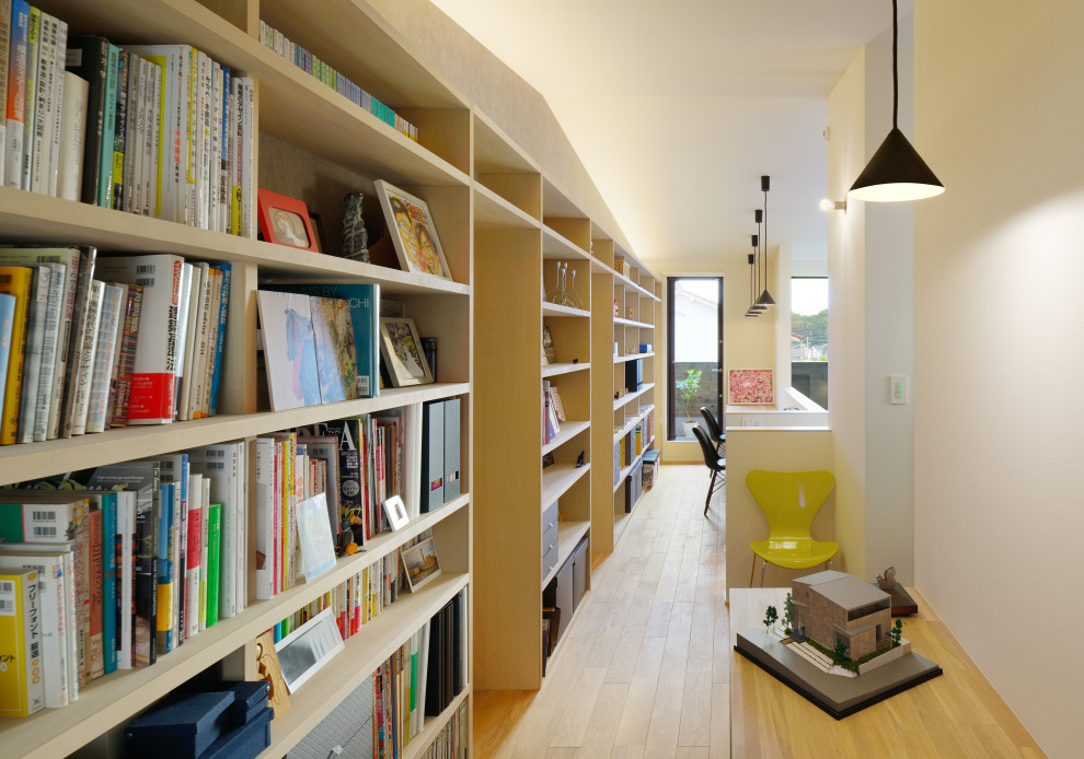 東京23区にある広いアジアンスタイルのおしゃれなホームオフィス・書斎 (ライブラリー、白い壁、淡色無垢フローリング、造り付け机、ベージュの床) の写真