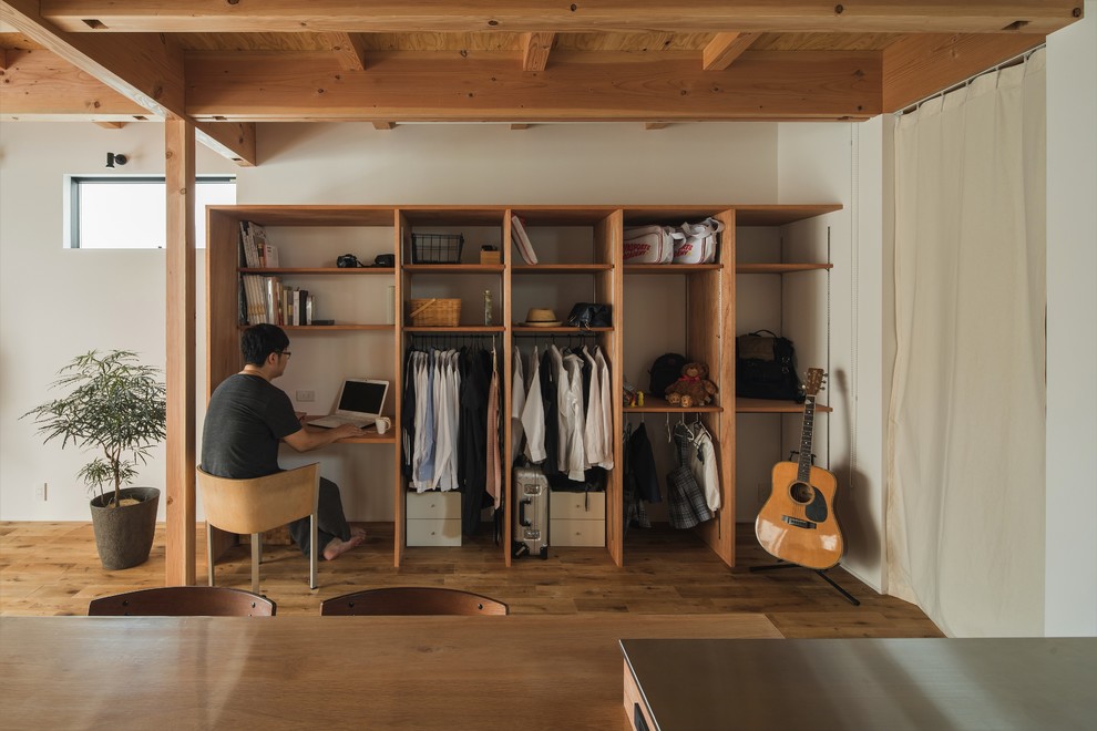 Immagine di un piccolo ufficio etnico con pareti bianche, pavimento in legno massello medio, scrivania incassata e pavimento beige