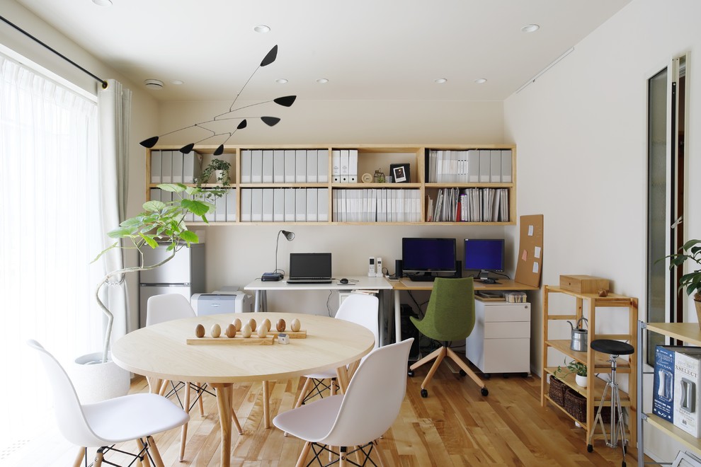 Ispirazione per uno studio moderno con pareti bianche, pavimento in legno massello medio, scrivania autoportante e pavimento marrone