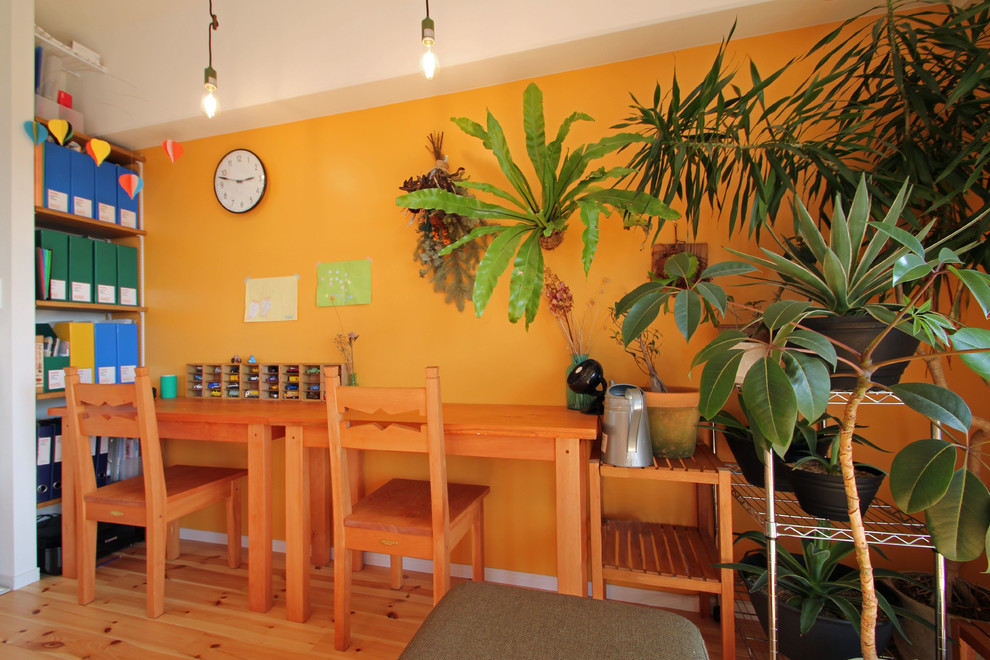 横浜にあるトロピカルスタイルのおしゃれなホームオフィス・書斎 (オレンジの壁、無垢フローリング、自立型机、茶色い床) の写真